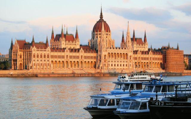 View of Hungarian Parliament Building at sunset with yachts on the Danube - Photo Credit: Immortal Shots